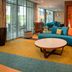 Fairfield Inn & Suites by Marriott Harrisburg International Airport lobby with teal sectional seating and orange accent wall in Middletown