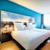 Nyx Hotel Mannheim by Leonardo Hotels guest room with king bed, blue accent wall and large window in Mannheim