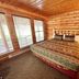The Lodge at Lolo Hot Springs guest room with wood-paneled walls, bed, and large windows in Lolo