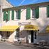 Logis Auberge La Cremaillere in Villandraut, storefront with yellow awnings and outdoor café tables
