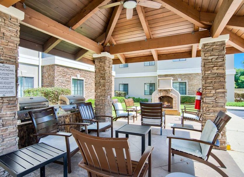 Staybridge Suites Gulf Shores covered patio with seating, stone columns, ceiling fans and outdoor fireplace