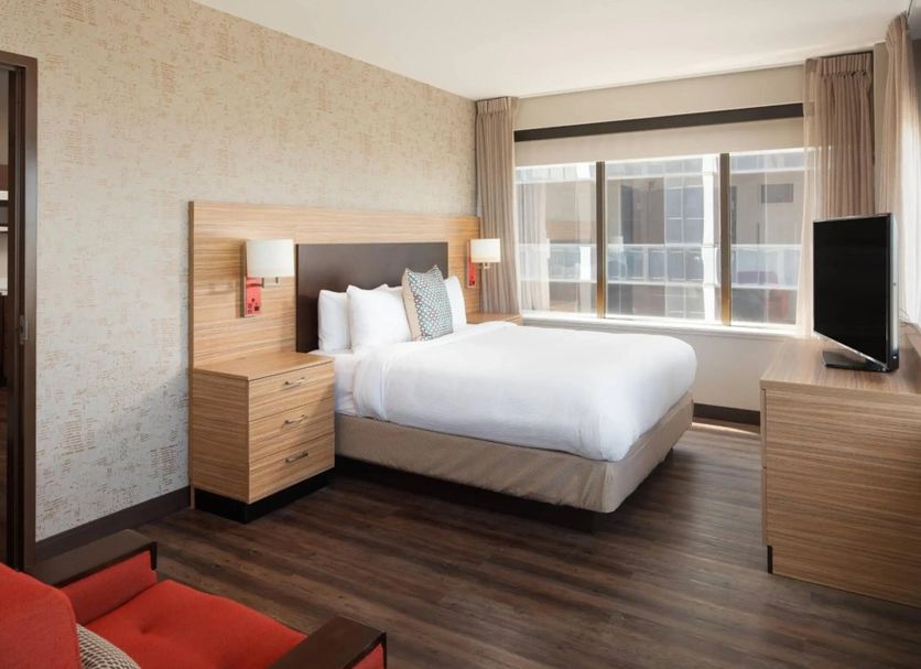 Canal Street New Orleans guest room with king bed, large window, TV, and wood floors