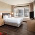 Canal Street New Orleans guest room with king bed, large window, TV, and wood floors