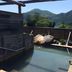 Minshuku Unagi Kohan in Ibusuki: outdoor hot spring bath with mountain and lake views