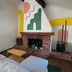 Piety Hill Cottages, Nevada City: cozy cottage living room with brick fireplace and colorful wall mural
