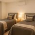 The Heritage Bendigo in Bendigo: twin beds, bedside lamp, curtain-covered window and wall-mounted AC