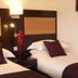 The Woodvale, Cowes: twin guest room with two beds, bedside lamp and dark wood headboard