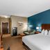 The Hotel Saratoga, Saratoga Springs guest room with king bed, teal accent wall and seating area