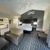 Baymont by Wyndham Indianapolis Airport Lynhurst room with king bed, sofa, and patterned carpet in Indianapolis