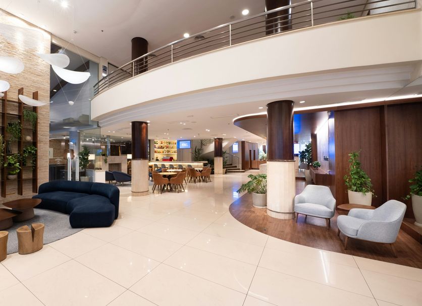 Blue Tree Towers Caxias do Sul lobby with curved mezzanine, lounge seating and dining area