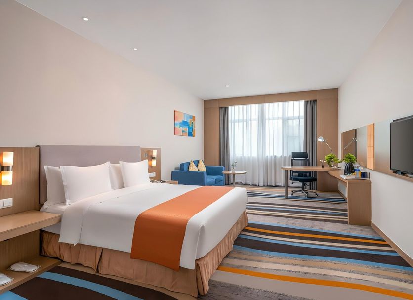 City Holiday Hotel Guangzhou Baiyun Airport Renhe Metro Exit B guest room with bed, desk and city view