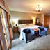 Lakeside Bed & Breakfast, Florence bedroom with king bed, two chairs, and lake artwork