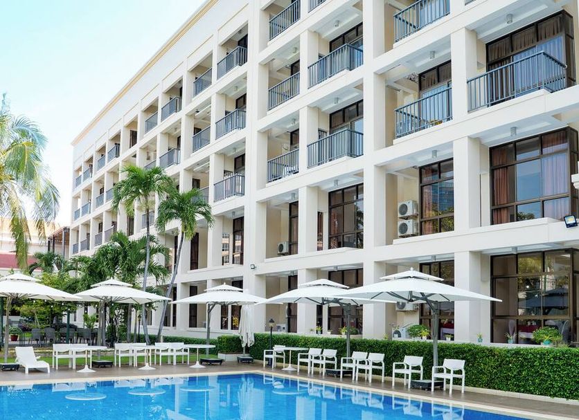 Ocean Sunrise Vung Tau in Vung Tau with a pool, palm trees, and a multi-story balcony facade