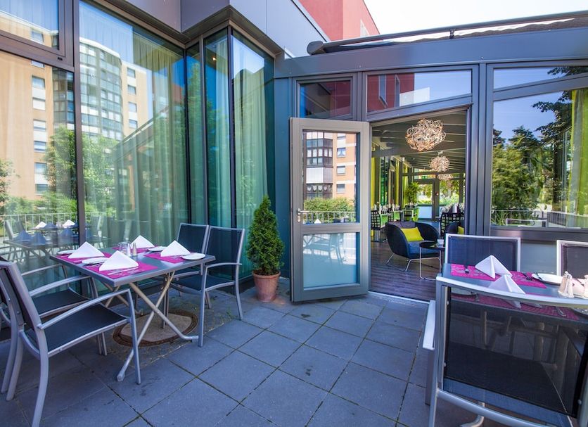 Novina Hotel Tillypark in Nuremberg with outdoor terrace seating beside floor-to-ceiling glass windows