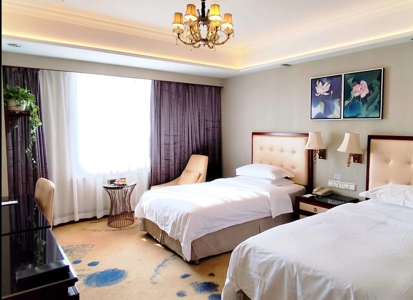 Ramada Plaza by Wyndham Tian Lu Hotel Wuhan room with two twin beds, window light and floral artwork