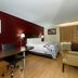 Red Roof Inn Hillsville room with bed, desk, chair and tan seating area