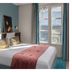 LYRIC Hotel Paris Opera guest room with king bed, teal walls and window view in Paris