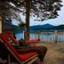 Lake Placid Lodge deck with red chairs overlooking Lake Placid and mountain views