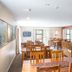 Shotover Lodge in Queenstown dining room with wooden tables, chairs, and stone fireplace