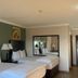 Hampshire Hotel - Ballito guest room with two double beds, bedside lamps and wall mirror in Ballito