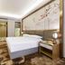 Fulai Garden Hotel in Shenzhen guest room with king bed, wall art, TV, and warm wood furnishings