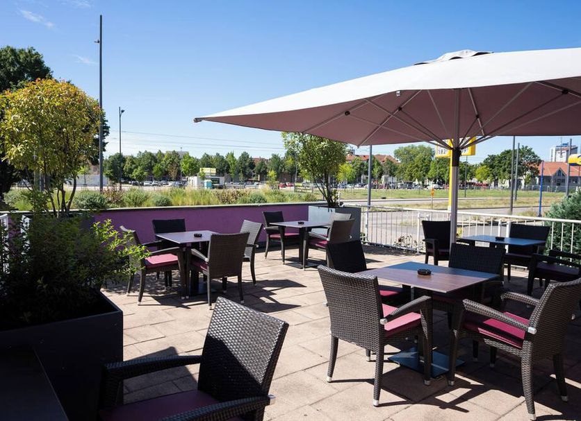 Europa Kehl Hotel outdoor terrace with tables, chairs, and large umbrellas in Kehl