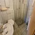 Zur Rotenfelsstube bathroom in Norheim with glass shower, toilet, sink and tiled walls