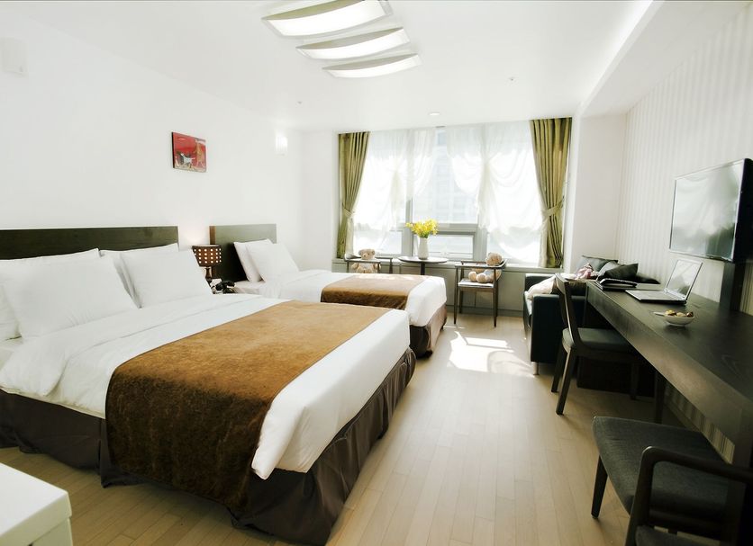 Hotel Hu Incheon Airport room with two beds, desk, TV and window seating in Incheon
