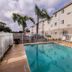 Studio 6 McAllen Tx pool area with lounge chairs, palm trees, and a three-story exterior