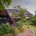 Haka Lodge Christchurch exterior with A-frame cabins and lush garden pathway