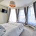 The Grove Cromer bedroom with bay windows, TV, and a bed in Cromer