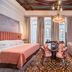 Palacio Gran Vía, a Royal Hideaway Hotel in Granada, elegant suite with bed, seating area, and ornate ceiling