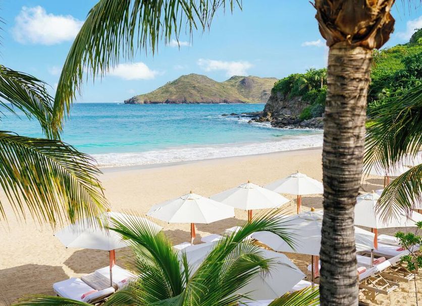 Cheval Blanc St-Barth beach with white umbrellas, palm trees and turquoise ocean in Gustavia