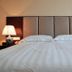 Qilu International Hotel Harbin guest room with king bed, upholstered headboard, and bedside lamps