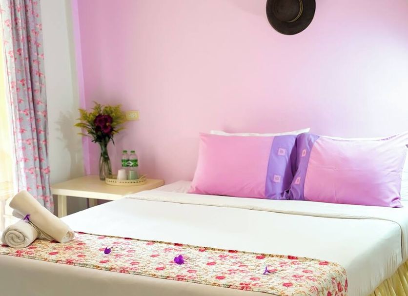 Les Fleurs House, Khao Lak: pink guest room with neatly made bed and floral bench runner
