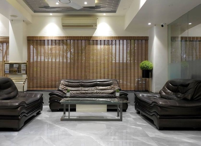 Hotel Sai Miracle in Shirdi lobby with black leather sofas and glass coffee table