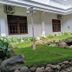 Narita Hotel Tulungagung garden courtyard with lawn, rocks, and a small pond