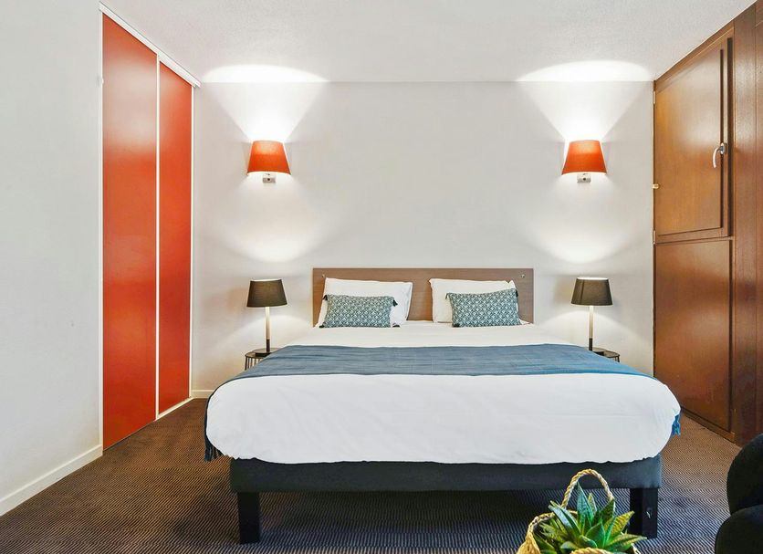 Appart'City Confort Lille Grand Palais bedroom in Lille with double bed and wood wardrobe