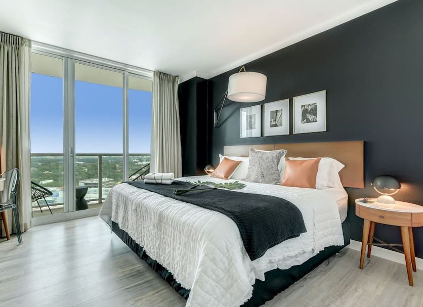 Icoconutgrove Vacation Rentals in Miami bedroom with balcony view and floor-to-ceiling windows
