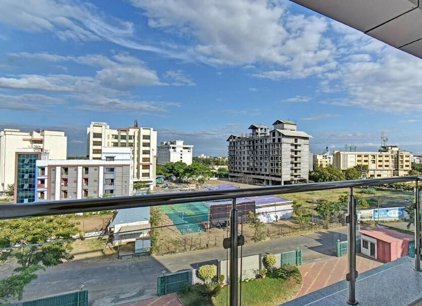 Sai Sangam Hotel in Shirdi balcony with glass railing and city view under a blue sky