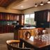 Hotel Duomo And Suites in Kampala kitchen with wooden cabinets, island, dining table and large window