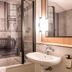 Campanile Bordeaux Ouest - Le Bouscat bathroom with tub, sink, mirror and black-and-white wall mural