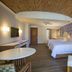 The Hacienda at Krystal Grand Puerto Vallarta room with two beds, patterned wall, and wood ceiling