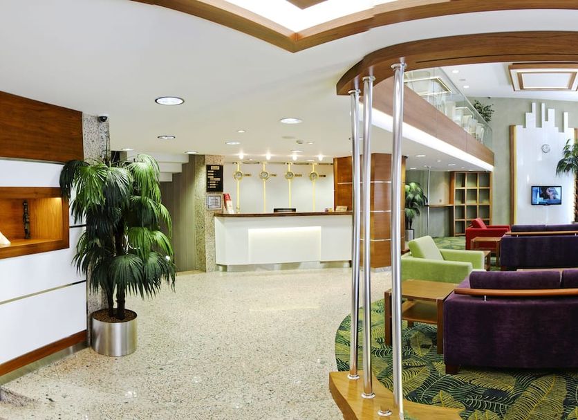 Bella Hotel in Istanbul lobby with reception desk, seating area, and potted palm