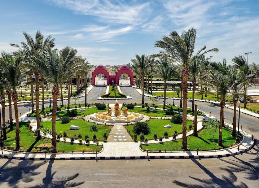 Swisstouch Oriental Resort in Al Quşayr with palm-lined entrance and landscaped roundabout