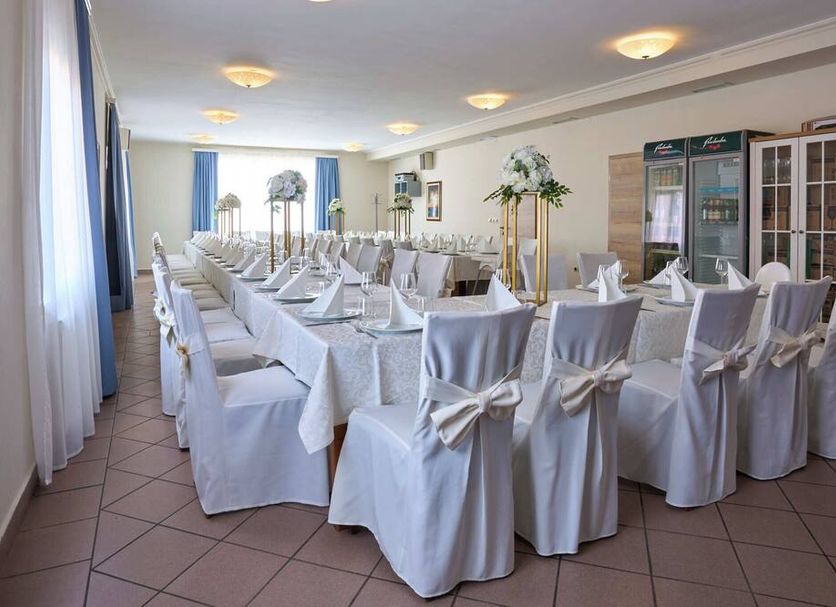 Hotel Phoenix in Velika Gorica banquet room set with white-covered chairs and tables for a hotel event