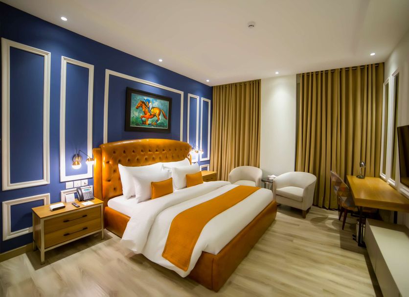 Best Western Premier Hotel Gulberg Lahore room in Lahore with king bed, blue accent wall and seating area