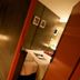Justbeds Bangkok hallway view beside a guest room with bed, warm lighting and mirrored wall