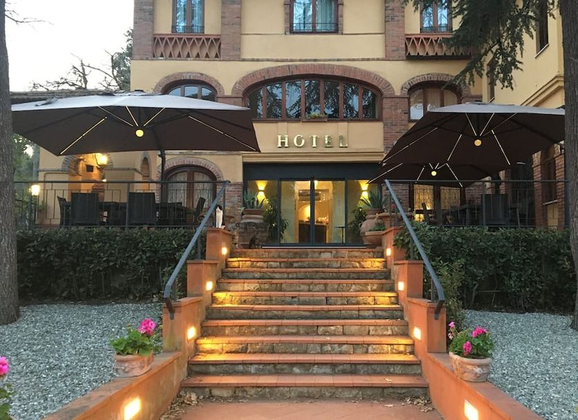 Villa Ambrosina in Impruneta with lit entrance steps, umbrellas, and a classic hotel facade