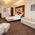 The Landmark Hotel, Baku guest room with king bed, sofa, chaise lounge and wall art